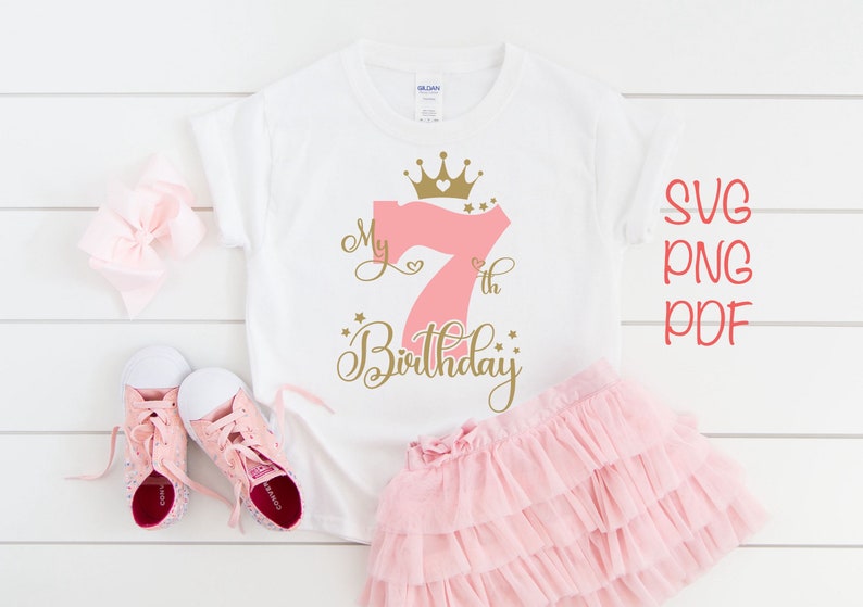 May include: A white t-shirt with a pink number seven and gold crown and text that says "My 7th Birthday".