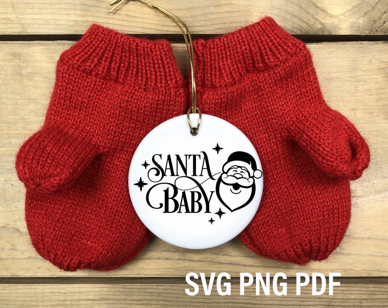 May include: Red knitted mittens with a white round ornament that says "Santa Baby" with a cartoon Santa Claus face.