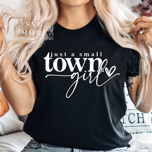 May include: A black t-shirt with white text that reads "Just a small town girl" with a small heart graphic.