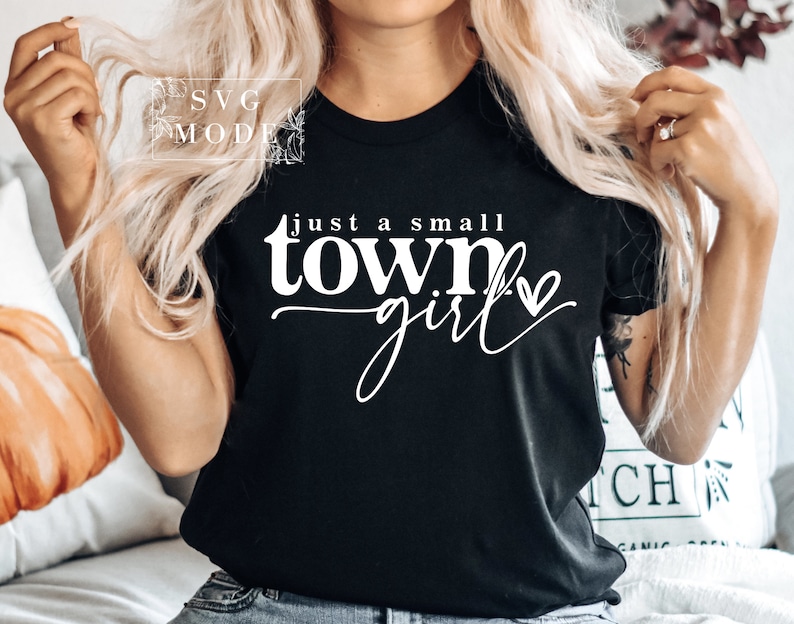 May include: A black t-shirt with white text that reads "Just a small town girl" with a small heart graphic.