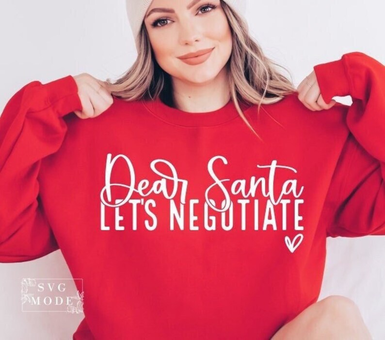 Pode incluir: Camisola de cor vermelha com texto branco que diz "Caro Papai Noel, vamos negociar" com um pequeno cora&ccedil;&atilde;o branco.