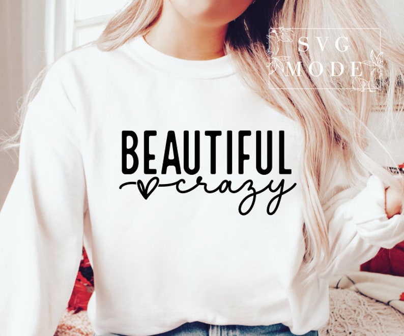 Pode incluir: Camisola branca de manga comprida com texto preto que diz "BEAUTIFUL crazy" com um pequeno s&iacute;mbolo de cora&ccedil;&atilde;o.
