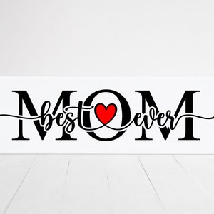 May include: White wooden sign with black lettering that reads "MOM best ever" with a red heart in the center.