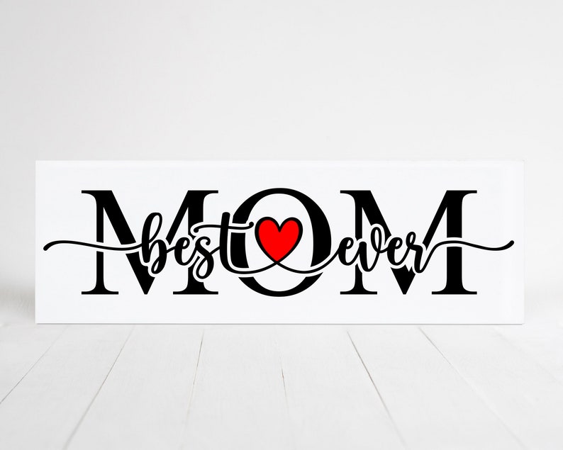 May include: White wooden sign with black lettering that reads "MOM best ever" with a red heart in the center.