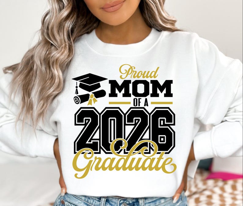 Puede incluir: Sudadera blanca con el texto "Proud MOM of a 2026 Graduate" en negro y dorado. El dise&ntilde;o incluye un gorro de graduaci&oacute;n, un diploma y el a&ntilde;o 2026. La sudadera es de estilo c&oacute;modo e informal.