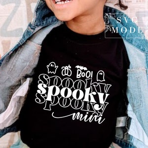 Puede incluir: Camiseta negra con texto blanco que dice "Spooky mini" con un fantasma, un murci&eacute;lago y una abeja.
