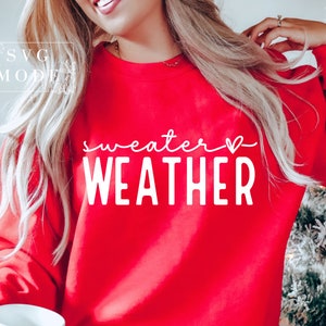 May include: Red sweatshirt with white text that says "sweater weather" with a small heart symbol.