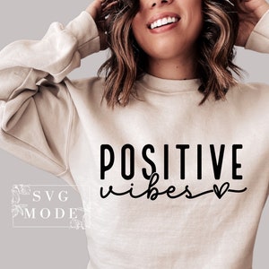 Peut inclure: Un sweat-shirt beige avec le texte "POSITIVE vibes" en lettres noires avec un petit symbole de c&oelig;ur.
