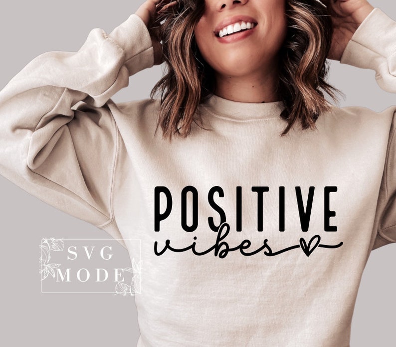 Peut inclure: Un sweat-shirt beige avec le texte "POSITIVE vibes" en lettres noires avec un petit symbole de c&oelig;ur.