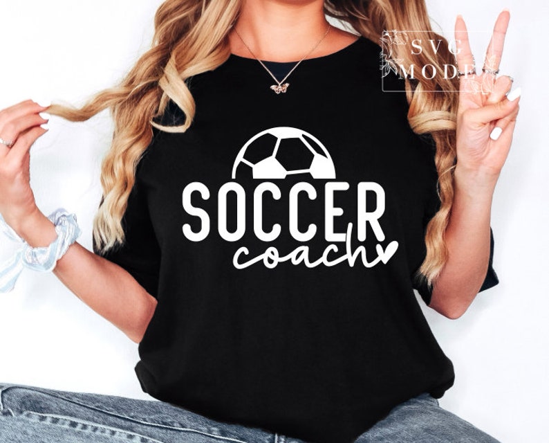 May include: A black t-shirt with a white football graphic and the text "SOCCER coach" with a heart.