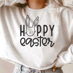 May include: A white sweatshirt with the text "Happy Easter" in black lettering. A black and white bunny illustration is above the text.