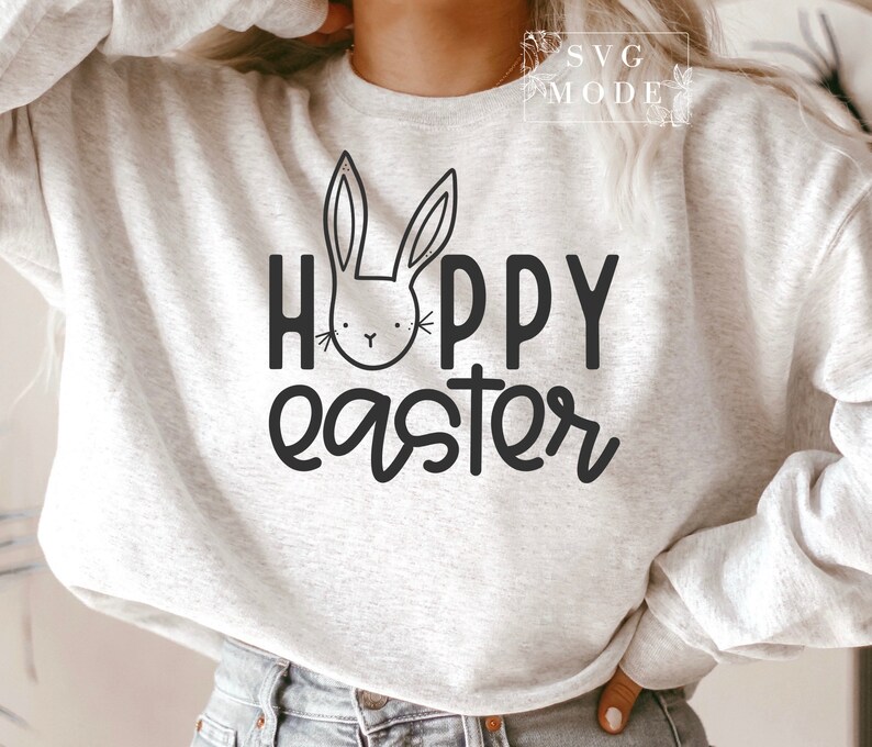May include: A white sweatshirt with the text "Happy Easter" in black lettering. A black and white bunny illustration is above the text.