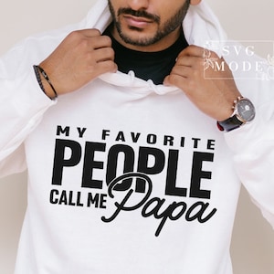 Peut inclure: Un sweat &agrave; capuche blanc avec l'inscription noire "MY FAVORITE PEOPLE CALL ME Papa". Le sweat &agrave; capuche a une capuche &agrave; cordon et une poche kangourou. Le texte est centr&eacute; sur le devant.
