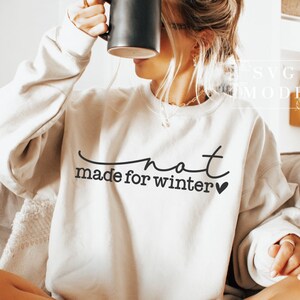 May include: A white sweatshirt with the text "not made for winter" in black lettering and a small heart.
