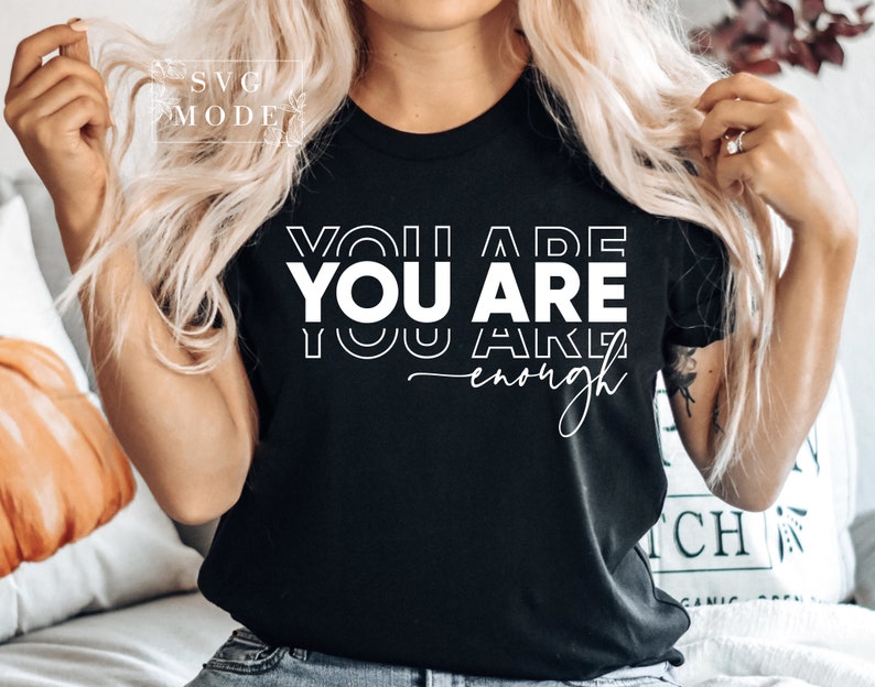 May include: Black t-shirt with white text that reads "You are You are You are enough".