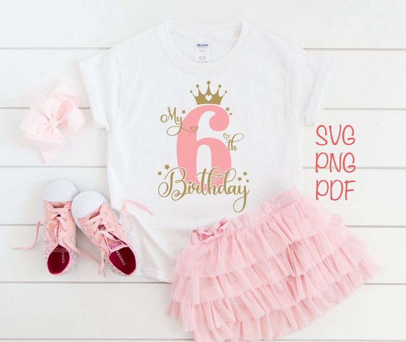 May include: A white t-shirt with a pink number six and gold crown, stars, and the text "My 6th Birthday".