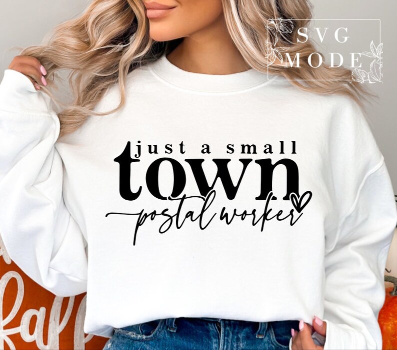 May include: White sweatshirt with black text that reads "Just a small town postal worker" with a small heart symbol.