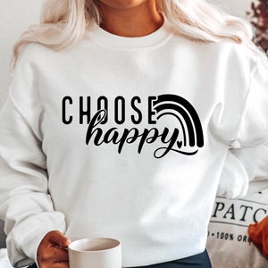 May include: White sweatshirt with black text that reads "Choose happy" and a rainbow graphic.