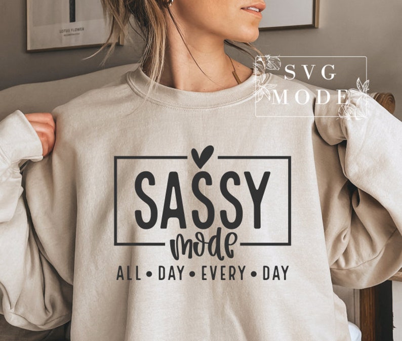 May include: A beige sweatshirt with the text "SASSY mode ALL DAY EVERY DAY" in black lettering. A small heart is above the word "SASSY".