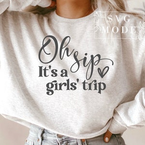 K&ouml;nnte beinhalten: Ein grauer Pullover mit dem Text "Oh sip it's a girls' trip" in schwarzer Schrift mit einem kleinen Herz.