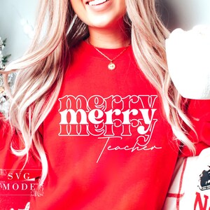 May include: Red sweatshirt with white text that reads "merry merry teacher" in a retro font.