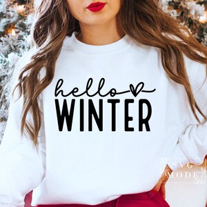May include: White sweatshirt with black text that says "hello winter" with a small heart symbol.