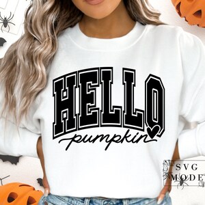 Może przedstawiać: Biała bluza z czarnym napisem "HELLO pumpkin" z małym czarnym sercem.