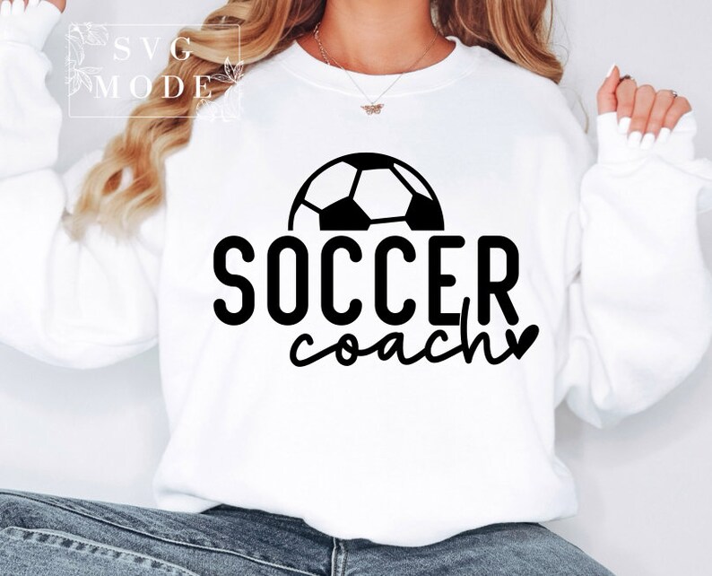 May include: White sweatshirt with a black football graphic and the text "SOCCER coach" with a heart.