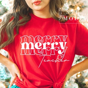 May include: Red t-shirt with white text that reads "merry merry teacher" in a retro font.
