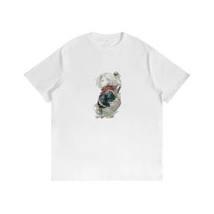 May include: A white short-sleeved t-shirt featuring a centered graphic illustration of a character with short blonde hair, wearing a dark jacket and a red scarf, surrounded by swirling smoke-like elements in a detailed, artistic style.