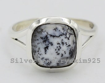 May include: A silver ring with a square-shaped white and black dendritic agate gemstone.