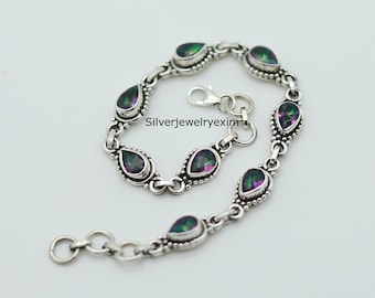 Peut inclure: Un bracelet en argent avec un design de chaîne à maillons et des pierres précieuses en forme de goutte. Les pierres précieuses sont irisées et présentent des nuances de vert, de violet et de noir. Le bracelet est doté d'un fermoir à homard. Silverjewelryexim est imprimé sur le bracelet.