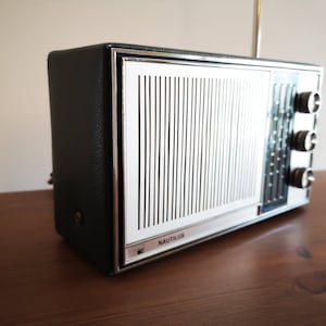 A good looking silver tone and leather Japanese 1970s radio. Ideal for display or film prop.
