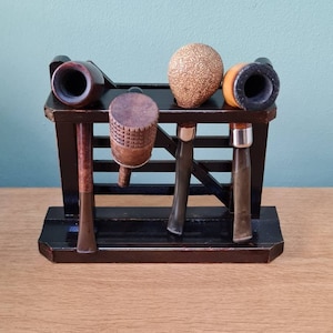 Vintage wooden gate-style pipe rack with four pipes