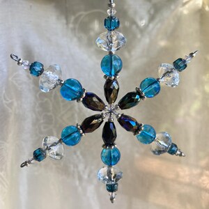 Snowflake Christmas ornament Turquoise glass, clear faceted rondelles and AB purple-black teardrop beads with silver accents.