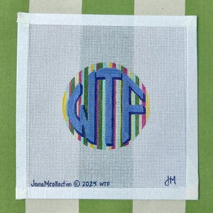 May include: Square needlepoint canvas with a blue monogram inside a striped circle. The monogram features the letters "WTF". The canvas is white with a white border. The text "JaneMcollection © 2023 WTF" is printed at the bottom.