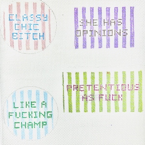 May include: White canvas with four embroidered phrases: "Classy Chic Bitch," "She Has Opinions," "Like a Fucking Champ," and "Pretentious As Fuck." Each phrase is in a different color and style, with striped backgrounds.