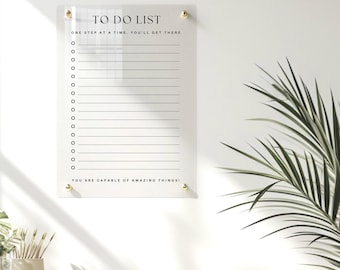 May include: A clear acrylic to-do list board with gold accents and the text "TO DO LIST" at the top. The board has a motivational quote: "ONE STEP AT A TIME, YOU'LL GET THERE" and "YOU ARE CAPABLE OF AMAZING THINGS!"