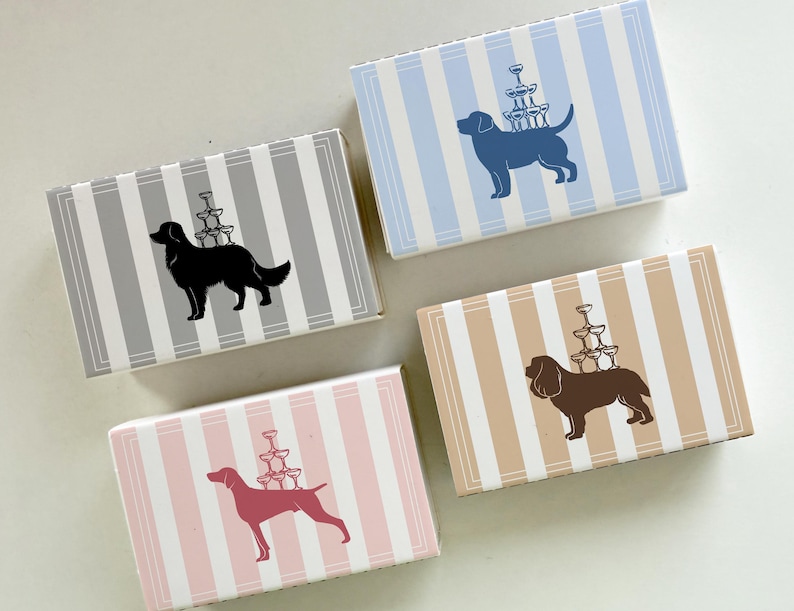 May include: Four rectangular boxes with striped patterns in gray, blue, tan, and pink. Each box features a dog silhouette carrying a stack of champagne glasses. The boxes are ideal for small gifts or party favors.