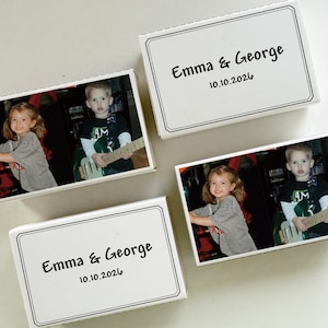 May include: Four white rectangular boxes with photos of two children. Two boxes have the text "Emma & George" and the date "10.10.2026". The photos show a girl and a boy, one holding a guitar.