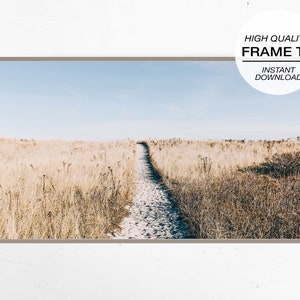May include: A framed print featuring a sandy path leading through tall, dry grass under a clear blue sky. The artwork has a neutral color palette with a light brown border. Text on the print reads "HIGH QUALITY FRAME TV INSTANT DOWNLOAD."