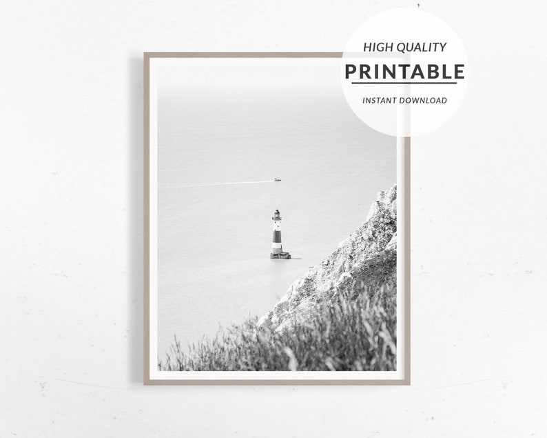 May include: Monochrome framed print featuring a lighthouse with red and white stripes, situated on a small island. The image includes the text "HIGH QUALITY PRINTABLE INSTANT DOWNLOAD". The sea and cliffs are also visible.