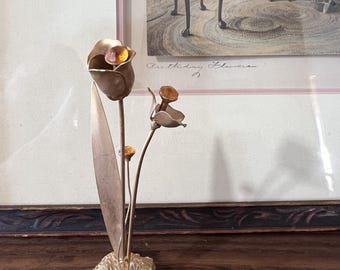 宝石がちりばめられた石の台座を備えたヴィンテージの金属製の花の彫刻