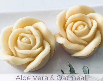 May include: Two pale yellow rose-shaped soaps. The soaps are unscented and gentle cleansing. The text on the image reads "Aloe Vera & Oatmeal" and "Sensitive Skin Friendly."