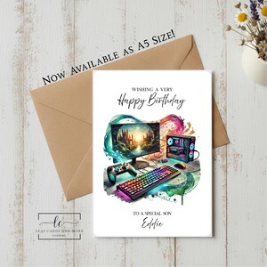 May include: A white birthday greeting card featuring a gaming setup illustration with a monitor, keyboard, controller, and computer tower surrounded by colourful watercolour splashes. The text reads: NOW AVAILABLE AS A5 SIZE! WISHING A VERY Happy Birthday TO A SPECIAL SON Eddie.