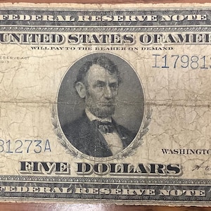Peut inclure: Un billet de banque vintage de cinq dollars de 1918, la Federal Reserve Note, présentant un portrait d'Abraham Lincoln au centre. Le billet affiche le texte The United States of America, Five Dollars, et le numéro de série I17981273A.