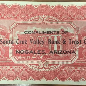 Peut inclure: Un billet de banque vintage rouge et blanc avec le texte "COMPLIMENTS OF Santa Cruz Valley Bank & Trust Co., NOGALES, ARIZONA." Le billet présente des motifs ornés, le chiffre "5" à plusieurs endroits et un sceau avec un aigle.