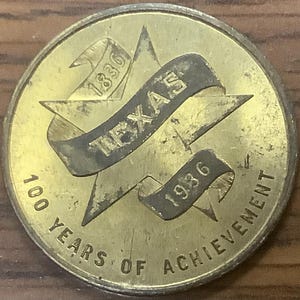 May include: A gold-colored coin with a five-pointed star and a banner that reads "TEXAS 1836 1936 100 YEARS OF ACHIEVEMENT".
