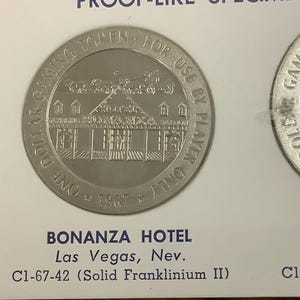 May include: Three vintage Bonanza Hotel gaming tokens from Las Vegas, Nevada. The tokens are round, with the hotel's facade depicted on each. The tokens are made of Solid Franklin Brass, Solid Franklinium II, and Bonded Silverclad.