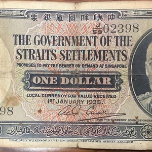 May include: A vintage one-dollar banknote from The Government of the Straits Settlements, issued on 1st January 1935. The bill displays a portrait and text in English and other languages. The note is rectangular.